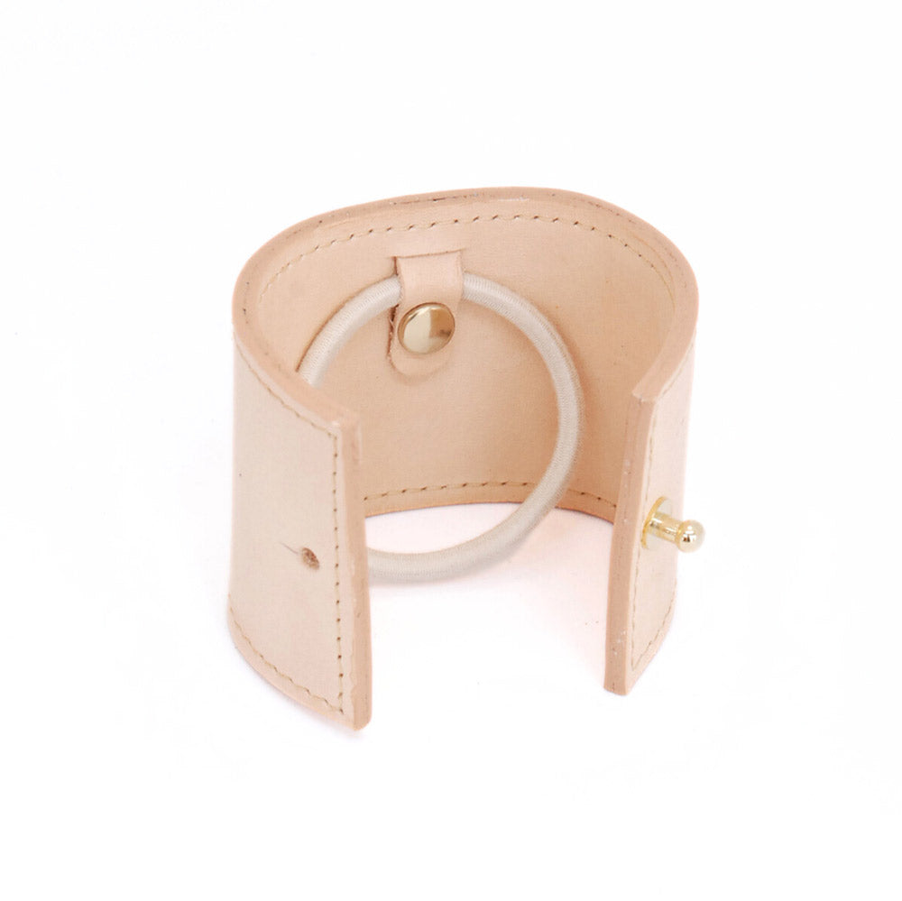 productshot tegen transparante achtergrond van leren long cover in kleur naturel. Open zodat zowel elastiek bevestigingssysteem als het sluitknopje zichtbaar is.