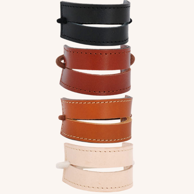 Beeld van 4 kleuren leren 2-straps uit de collectie. Onder elkaar, tegen een licht gekleurde achtergrond. Van boven naar onder: zwart, sienna bruin, cognac en naturel.