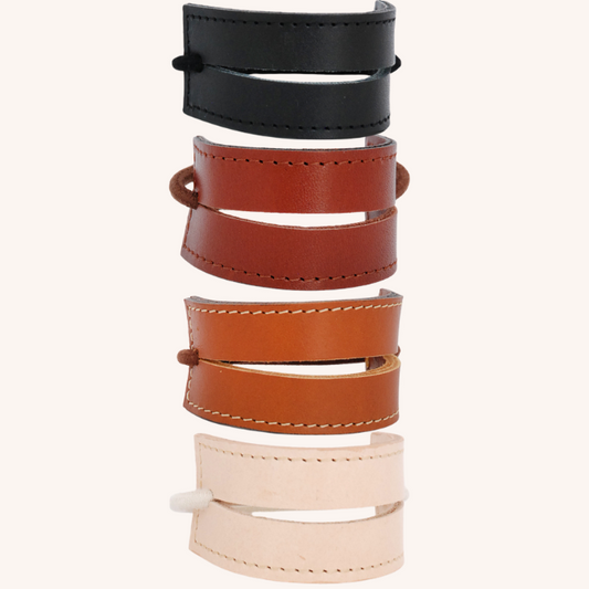 Beeld van 4 kleuren leren 2-straps uit de collectie. Onder elkaar, tegen een licht gekleurde achtergrond. Van boven naar onder: zwart, sienna bruin, cognac en naturel.